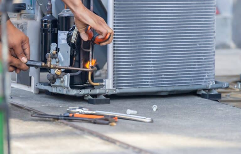Close up of Air Conditioning Repair team use fuel gases and oxygen to weld or cut metals, Oxy fuel welding and oxy fuel cutting processes, repairman on the floor fixing air conditioning system